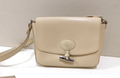 beige leather purse with a metal clasp on a white surface