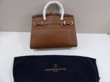 a brown purse sitting on top of a white table next to a blue bag