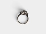 a close up of a diamond ring on a white surface