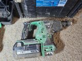 a cordless drill that is sitting on the floor next to other tools