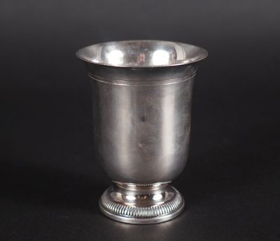 une coupe en argent posée sur un socle, sur fond noir