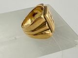 a gold ring sitting on top of a clear shelf