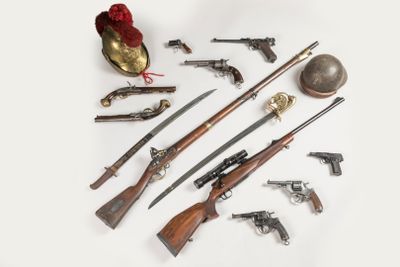 de nombreux types d'armes à feu et d'autres objets posés sur la table