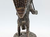 statue of a dog carrying a basket on its back