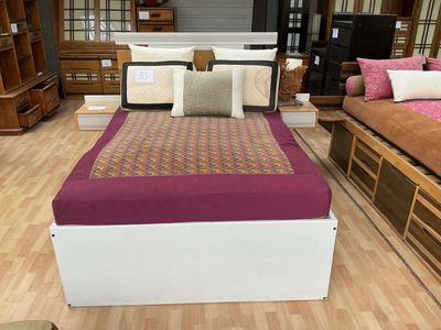 un lit qui se trouve dans une pièce où il y a beaucoup de meubles