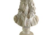 statue d'une femme aux cheveux longs, vêtue d'une robe blanche, posée sur un socle