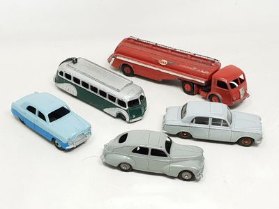 four toy cars and a bus on a white surface