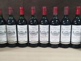 a group of bottles of wine sitting on top of a wooden table