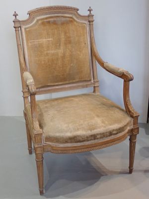 a wooden chair with a tan upholstered upholstered seat
