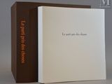 Le livre est ouvert et posé sur la table, à côté de la boîte.