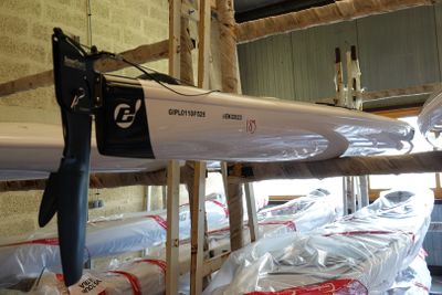 une rangée de kayaks posés sur un support à l'intérieur d'un bâtiment