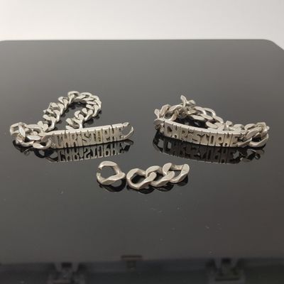 deux bijoux en argent posés sur une table noire