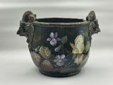 a vase with flowers painted on it sitting on a table