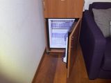 a blue couch and a small cabinet in the corner of a room