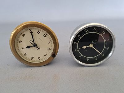 two clocks sitting next to each other on a table