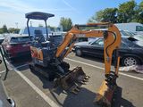 une petite excavatrice garée sur un parking