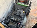 two lawn mowers sitting next to each other on the ground
