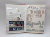 an open book with stamps on it on a table