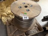 une bobine de fil métallique posée sur une palette dans un entrepôt