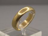 un gros plan d'une bague en or posée sur un socle transparent