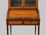 an antique writing desk with two drawers and glass doors