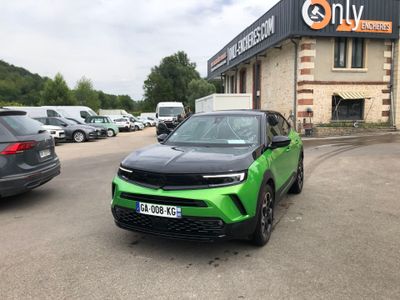a green car parked in front of a building