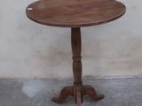 a small table with a wooden top on a concrete floor