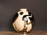 un vase noir et blanc posé sur une table en bois