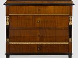 une commode ancienne en bois, avec un plateau noir et des garnitures dorées