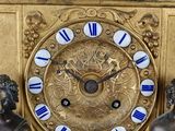a gold clock with blue and white roman numerals on it