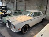 two old cars parked in a garage next to each other