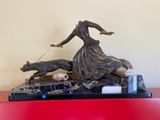 a statue of a woman walking a dog on a leash