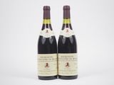 deux bouteilles de vin posées l'une à côté de l'autre sur une surface blanche