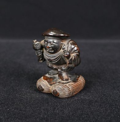 un gros plan d'une figurine représentant une personne posée sur une surface noire