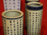 trois récipients portant des inscriptions en caractères asiatiques, posés sur un tissu rouge