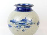a blue and white vase sitting on a white surface