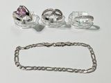 trois bagues et un bracelet posés sur une table