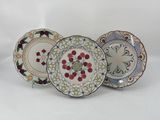 trois assiettes ornées de motifs sont posées sur une surface blanche