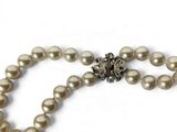 pearl necklace with a silver clasp on a white background