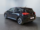 the back of a black car in a room with a white wall