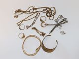 beaucoup de bijoux en or et en argent sur une surface blanche