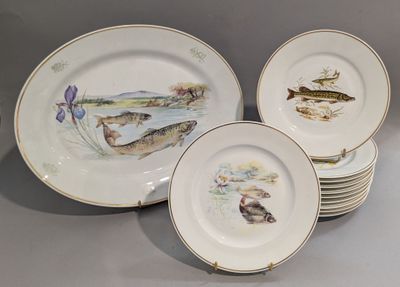 plusieurs assiettes sur lesquelles sont peints des poissons, posées sur une table
