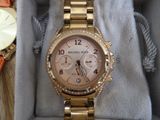 a gold watch in a box with a watch on it