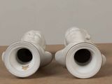 two white vases that are sitting on a table