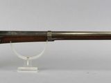 an old gun with a wooden handle on a white surface