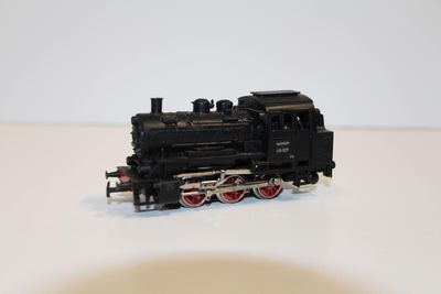 un petit train sur une surface blanche avec un fond blanc