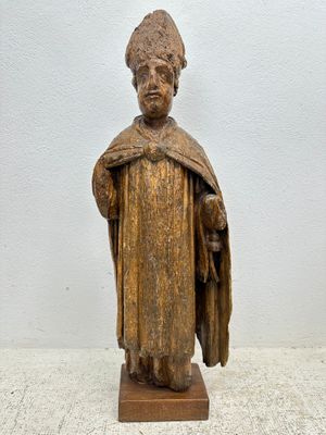 statue en bois représentant un homme portant un chapeau et une robe
