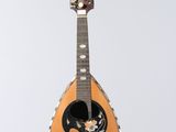 a guitar hanging from a string on a white wall
