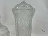 two clear glass vases sitting next to each other on a white surface