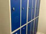 Plusieurs casiers bleus sont alignés les uns à côté des autres dans une salle de bains